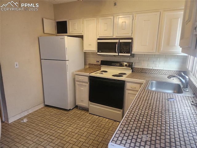 805 E 7th Ave Unit 8, Denver, CO 80218 - kitchen with electric range oven, freestanding refrigerator, stainless steel microwave, a sink, and tile counters