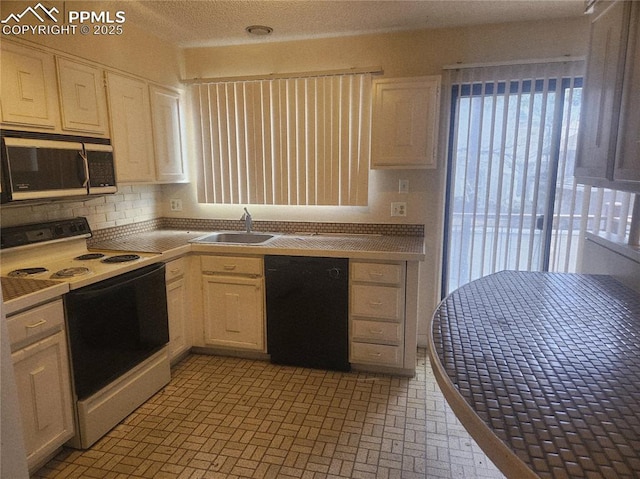 805 E 7th Ave Unit 8, Denver, CO 80218 - kitchen with electric range, dishwasher, tile counters, brick patterned floors, and white cabinetry