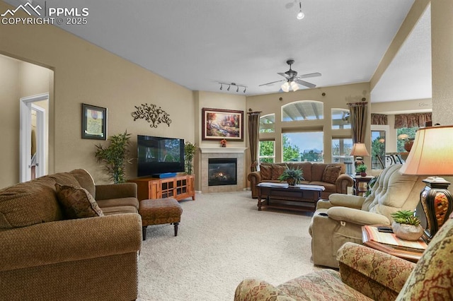 carpeted living area with rail lighting, ceiling fan, and a fireplace