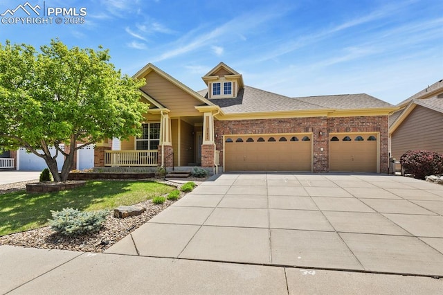 craftsman-style home featuring a garage, concrete driveway, brick siding, covered porch, and a front yard