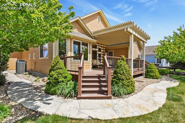 view of front of property featuring a wooden deck, cooling unit, and a pergola