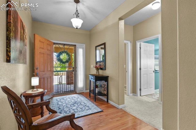 foyer entrance with light wood finished floors and baseboards