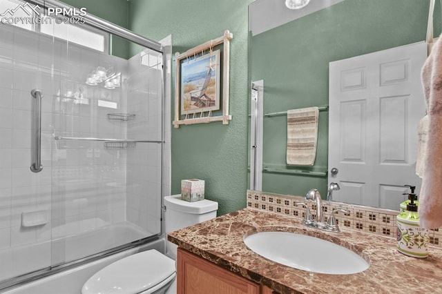 bathroom featuring a textured wall, toilet, enclosed tub / shower combo, and vanity