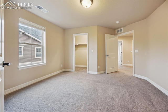8451 Meadow Wing Cir, Colorado Springs, CO 80927 - unfurnished bedroom featuring light colored carpet, baseboards, and a walk in closet