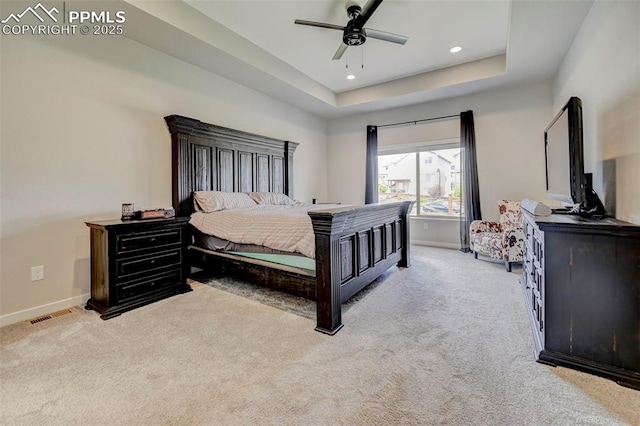 carpeted bedroom featuring baseboards, a tray ceiling, recessed lighting, and a ceiling fan
