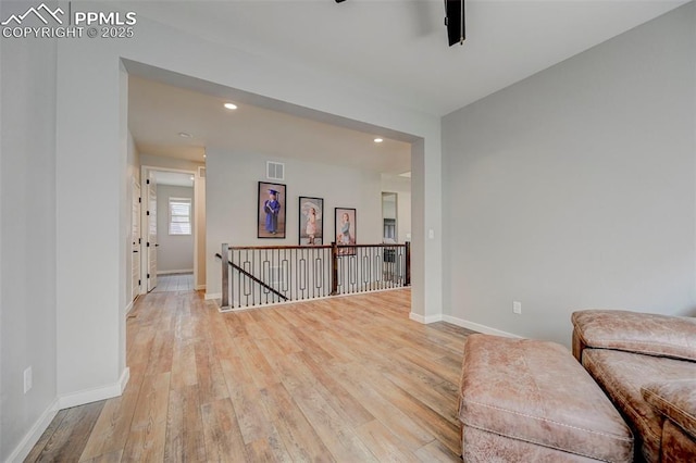 sitting room featuring an upstairs landing, light wood finished floors, recessed lighting, and baseboards