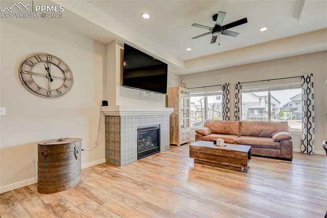 living room featuring baseboards, wood finished floors, recessed lighting, a tile fireplace, and ceiling fan