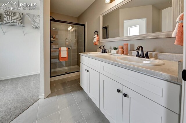 7367 Cornice Pt, Colorado Springs, CO 80923 - bathroom with a shower stall, tile patterned flooring, double vanity, and baseboards
