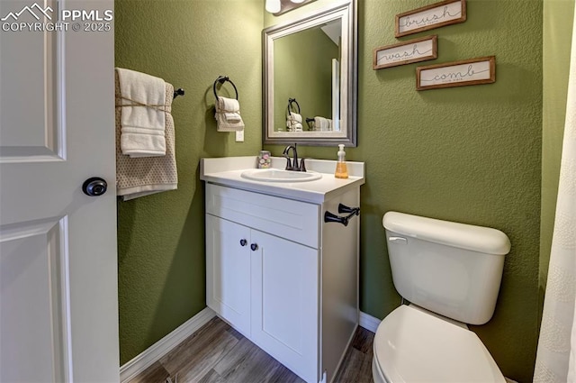 7367 Cornice Pt, Colorado Springs, CO 80923 - bathroom with wood finished floors, toilet, vanity, and baseboards
