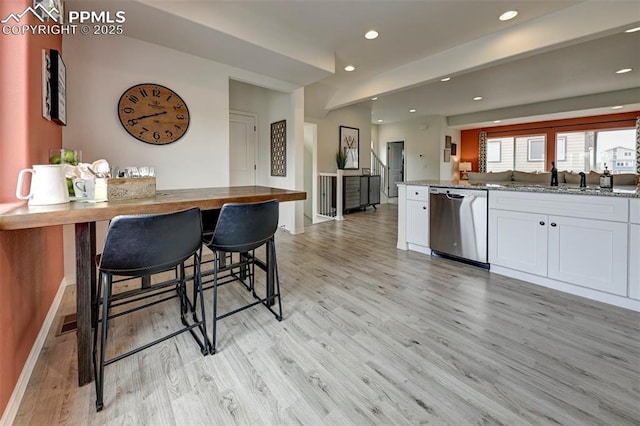 7367 Cornice Pt, Colorado Springs, CO 80923 - kitchen with stainless steel dishwasher, white cabinets, light wood-style floors, recessed lighting, and baseboards