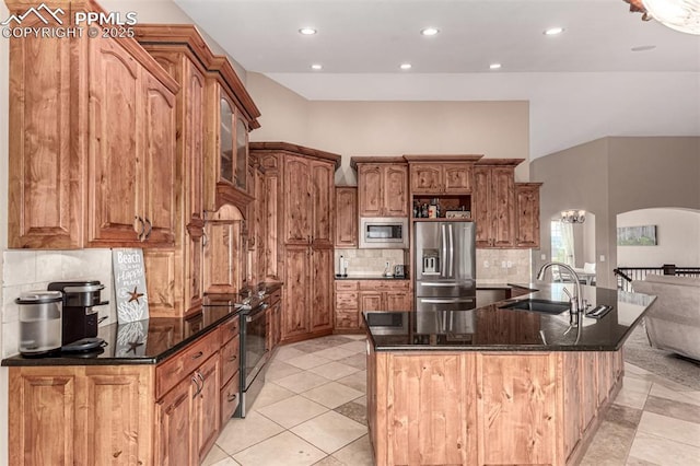 20097 Royal Troon Dr, Monument, CO 80132 - kitchen with appliances with stainless steel finishes, a sink, arched walkways, recessed lighting, and backsplash