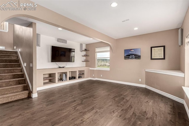 20097 Royal Troon Dr, Monument, CO 80132 - unfurnished living room with dark wood-style floors, arched walkways, recessed lighting, baseboards, and stairway