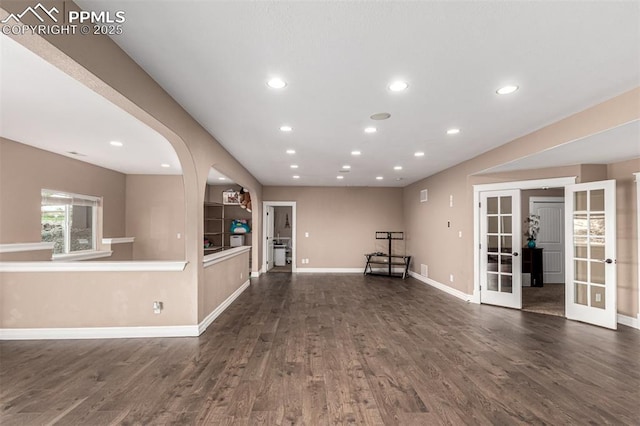 20097 Royal Troon Dr, Monument, CO 80132 - unfurnished living room with french doors, dark wood finished floors, recessed lighting, baseboards, and arched walkways