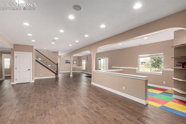 20097 Royal Troon Dr, Monument, CO 80132 - unfurnished living room with arched walkways, baseboards, wood finished floors, and recessed lighting