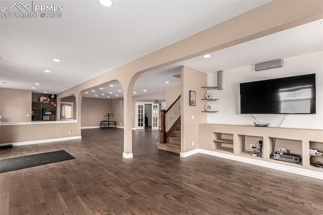 20097 Royal Troon Dr, Monument, CO 80132 - unfurnished living room with arched walkways, wood finished floors, baseboards, and recessed lighting