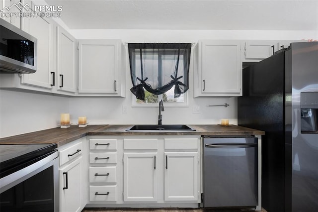 kitchen featuring stainless steel appliances, a sink, and white cabinets
