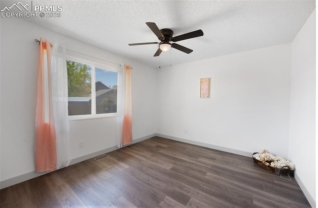 empty room with wood finished floors, ceiling fan, a textured ceiling, and baseboards