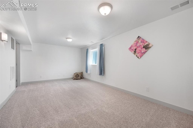 spare room featuring carpet floors and baseboards