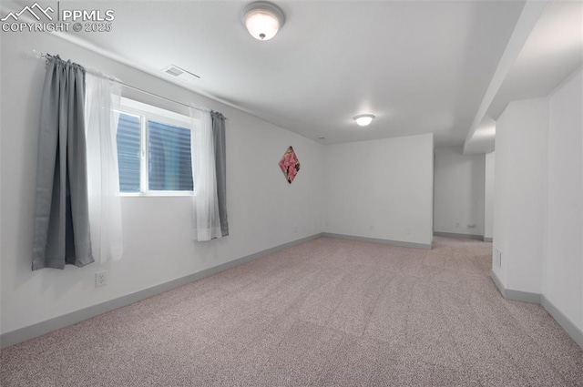 unfurnished room featuring light carpet and baseboards