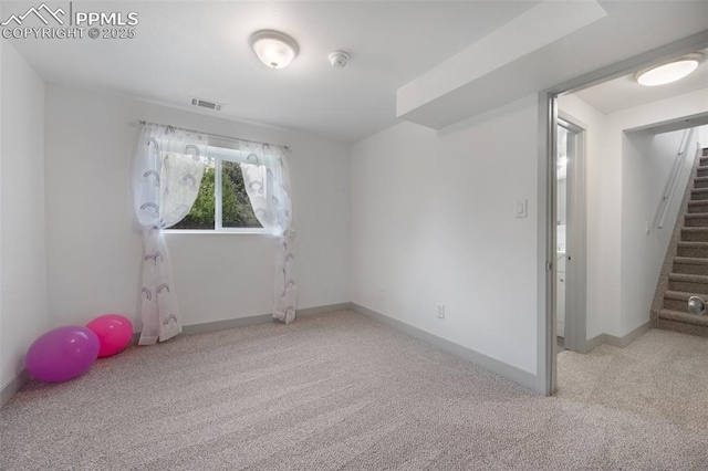 carpeted empty room featuring stairs, baseboards, and a smoke detector