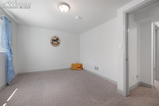 spare room with carpet flooring, baseboards, and a smoke detector
