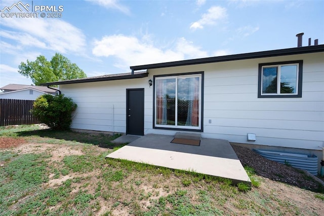 back of property with fence and a patio area