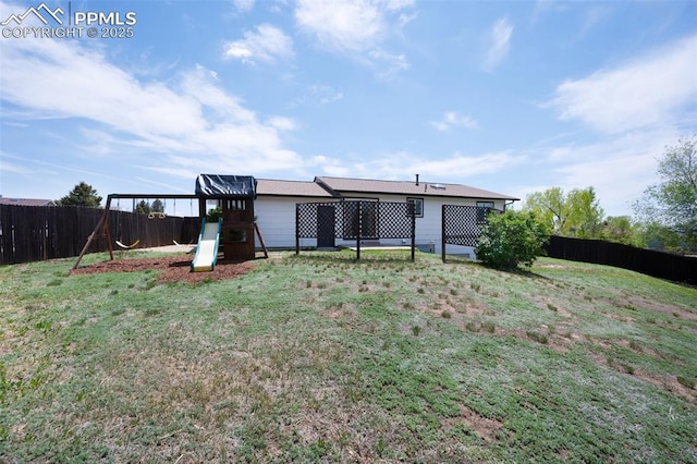rear view of property with a playground