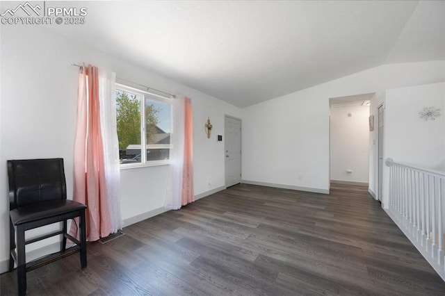 unfurnished living room featuring wood finished floors, lofted ceiling, and baseboards