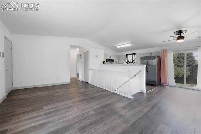 kitchen featuring stainless steel appliances, dark wood-style floors, open floor plan, a peninsula, and vaulted ceiling