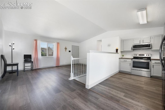 kitchen with appliances with stainless steel finishes, lofted ceiling, dark wood-style flooring, baseboards, and open floor plan