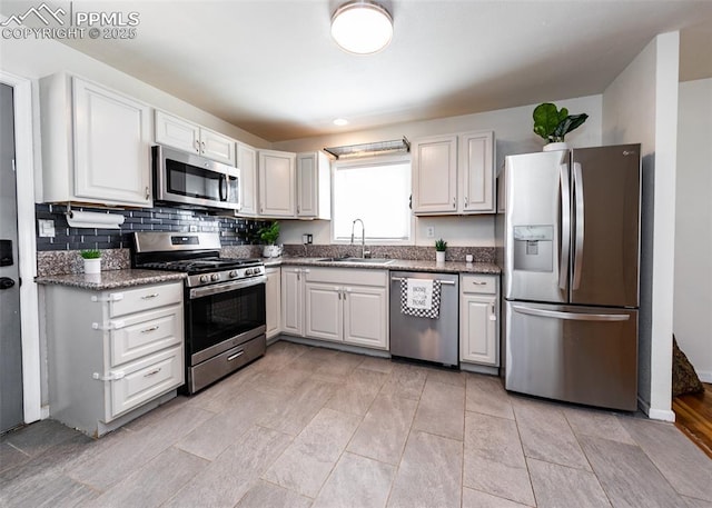 1036 Florence Ave, Colorado Springs, CO 80905 - kitchen featuring appliances with stainless steel finishes, a sink, decorative backsplash, white cabinetry, and stone countertops