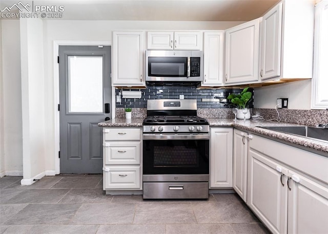 1036 Florence Ave, Colorado Springs, CO 80905 - kitchen featuring stainless steel appliances, white cabinetry, baseboards, and backsplash