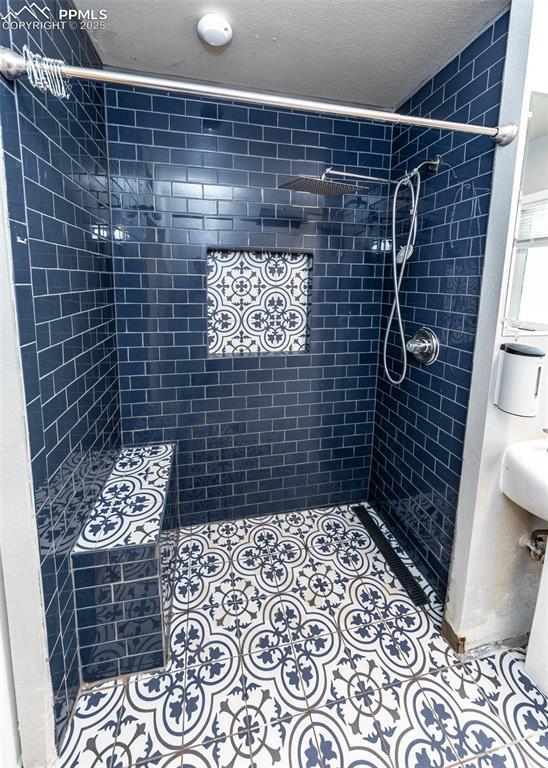 1036 Florence Ave, Colorado Springs, CO 80905 - bathroom featuring a tile shower and a textured ceiling