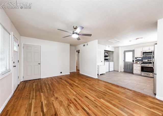 1036 Florence Ave, Colorado Springs, CO 80905 - unfurnished living room featuring washer and dryer, light wood-style flooring, ceiling fan, and baseboards