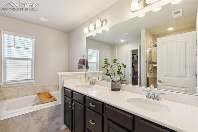 full bath featuring a shower stall, a bath, and double vanity