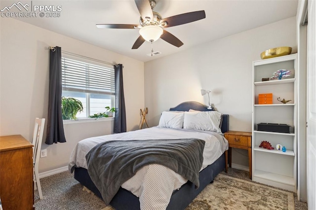 carpeted bedroom featuring baseboards and a ceiling fan