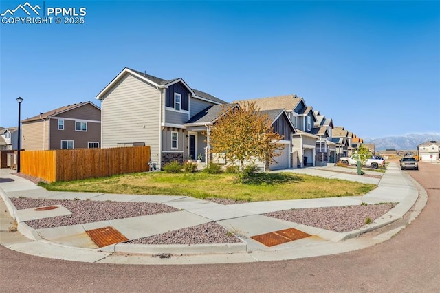 view of front facade with a residential view, concrete driveway, and an attached garage