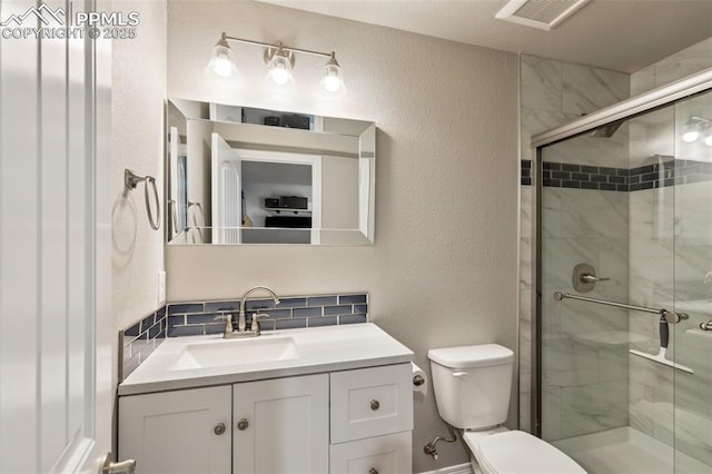 full bath featuring a shower stall, vanity, toilet, a textured wall, and tasteful backsplash