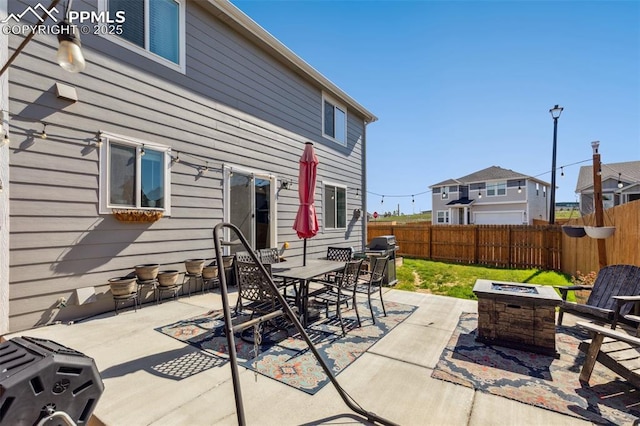 view of patio / terrace featuring a fire pit, a fenced backyard, area for grilling, and outdoor dining space