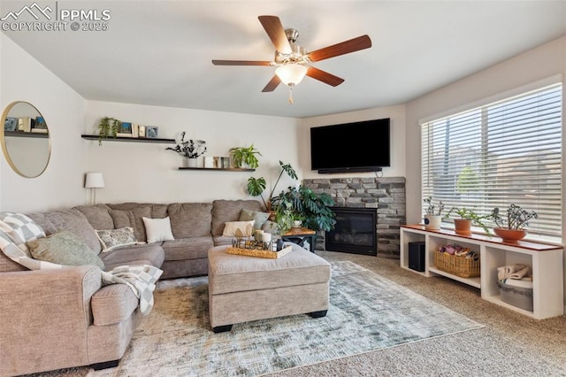 living room with ceiling fan, carpet, and a fireplace