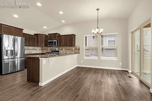 4479 Hessite Loop, Colorado Springs, CO 80938 - kitchen featuring appliances with stainless steel finishes, vaulted ceiling, dark wood-style flooring, a peninsula, and a chandelier