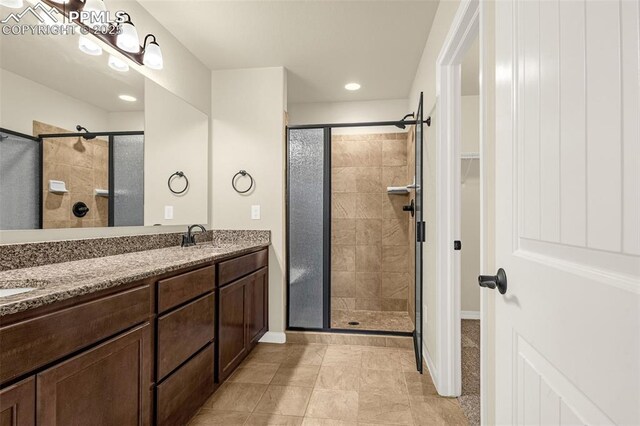 4479 Hessite Loop, Colorado Springs, CO 80938 - bathroom with a shower stall, double vanity, tile patterned floors, recessed lighting, and baseboards