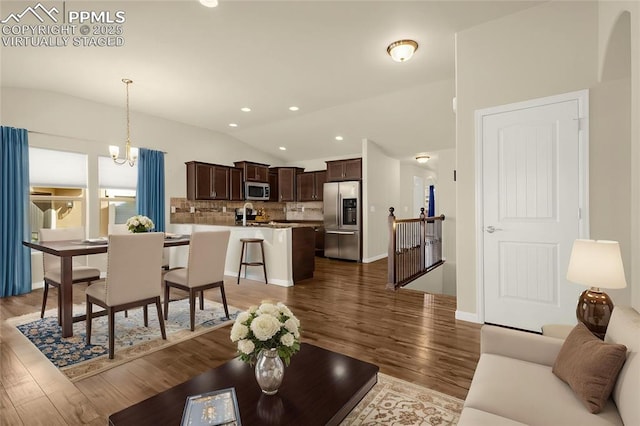 4473 Hessite Loop, Colorado Springs, CO 80938 - living room featuring lofted ceiling, dark wood-style floors, recessed lighting, and arched walkways