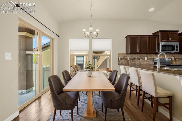 4473 Hessite Loop, Colorado Springs, CO 80938 - dining area featuring vaulted ceiling, a chandelier, and wood finished floors