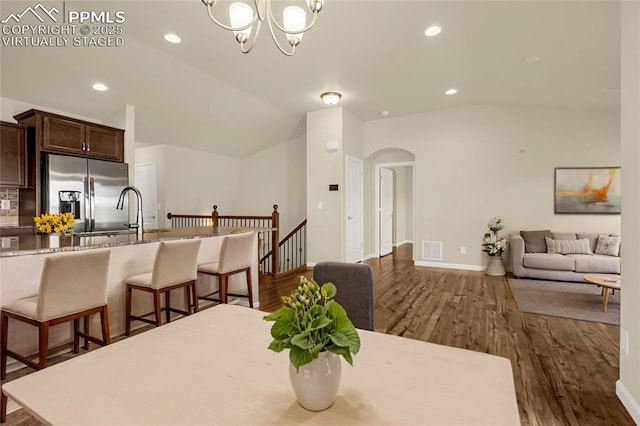 4473 Hessite Loop, Colorado Springs, CO 80938 - dining space with lofted ceiling, wood finished floors, arched walkways, a chandelier, and recessed lighting