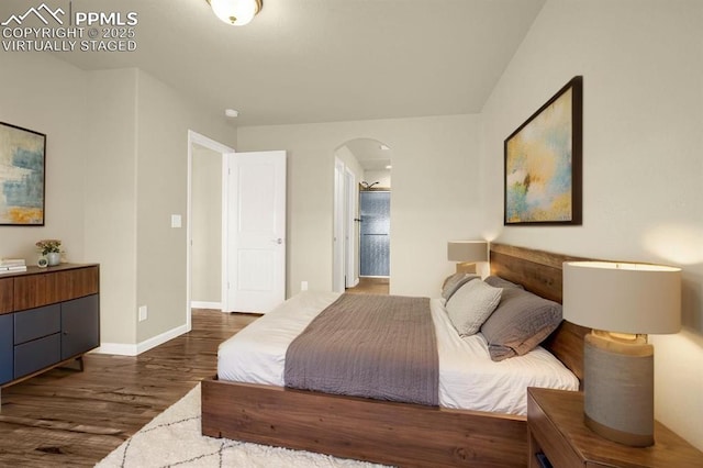 4473 Hessite Loop, Colorado Springs, CO 80938 - bedroom featuring arched walkways, dark wood-style floors, baseboards, and ensuite bathroom