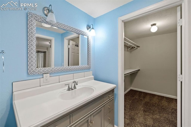 1308 Mesa Ave, Colorado Springs, CO 80906 - bathroom featuring vanity, a walk in closet, and baseboards