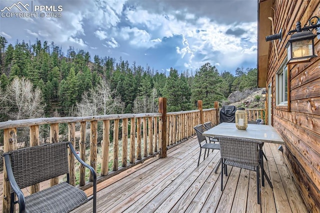 1978 High Chateau Rd, Florissant, CO 80816 - wooden deck with outdoor dining area and a wooded view