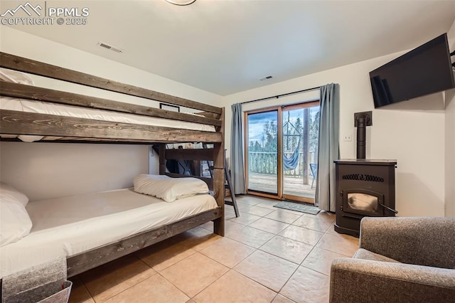 1978 High Chateau Rd, Florissant, CO 80816 - bedroom with a wood stove, access to outside, and light tile patterned floors