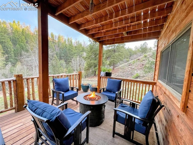1978 High Chateau Rd, Florissant, CO 80816 - wooden deck with an outdoor fire pit and a forest view